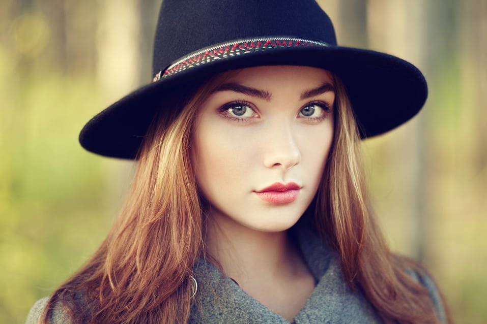 Portrait of young beautiful woman in autumn coat. Girl in hat. Fashion photo. Are you SunSmart?